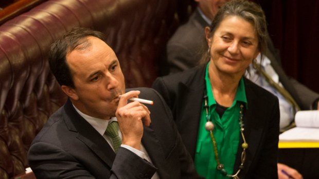 Greens MP Jeremy Buckingham lights an e-cigarette in the NSW Upper House to show how lax the laws are that govern the devices.