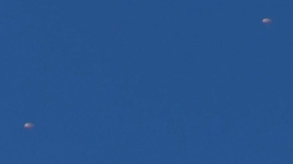 Two parachutes are seen after a Russian warplane was shot down over Turkey.