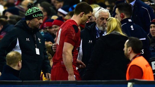 Wales player George North  leaves the field for a concussion test in the first half.