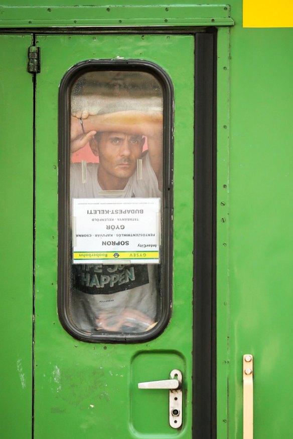 A man stands inside the door of the train he is refusing to leave in Bicske.