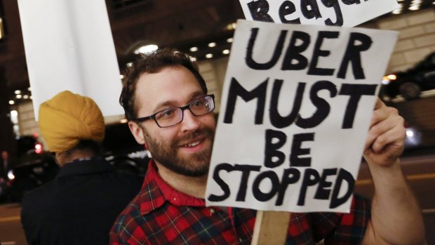 Demonstrators hold signs during a protest in San Francisco against ridesharing services Uber and Lyft. 