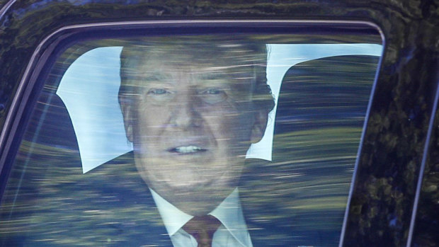  Former President Donald Trump looks out his window as his motorcade drives through West Palm Beach, Florida.