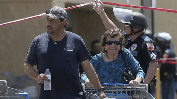 Walmart customers are escorted from the store after a gunman opened fire on shoppers.