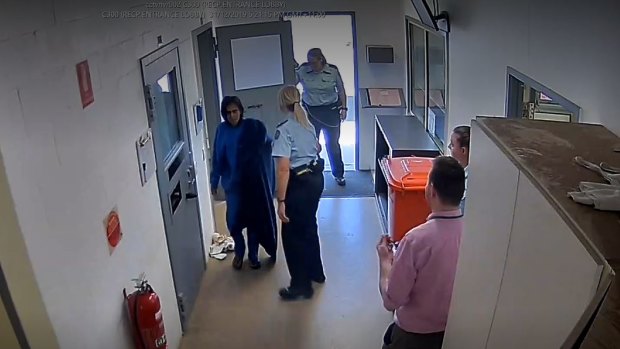 Veronica Nelson, left, is seen walking through prison halfway near doctor Sean Runacres, far right.