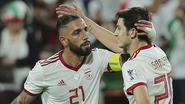 Iran midfielder Ashkan Dejagah (left) celebrates with teammate Sardar Azmoun.