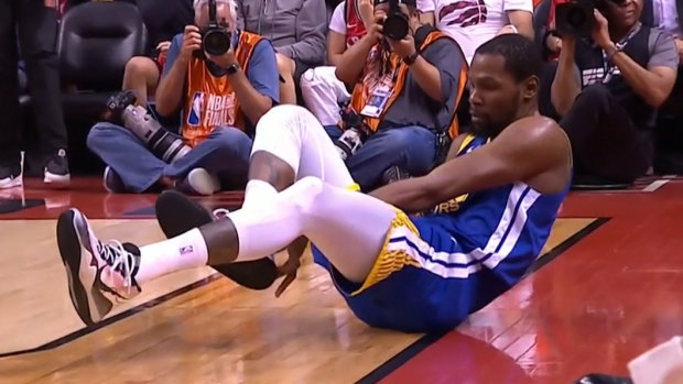 Kevin Durant drops to the court clutching his calf in the second quarter of NBA finals game five.