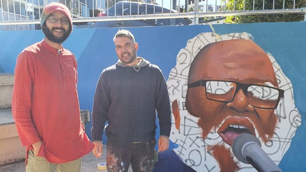 Gabba councillor Jonathan Sri (left) and artist Warraba Weatherall in front of an art mural dedicated to the late Brisbane Aboriginal activist Sam Watson.