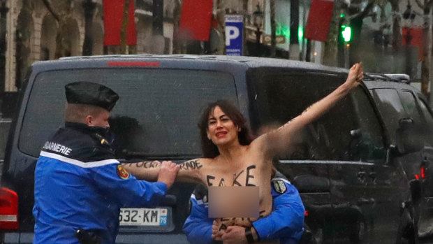 A topless protester gets close to US President Donald Trump's motorcade in Paris.