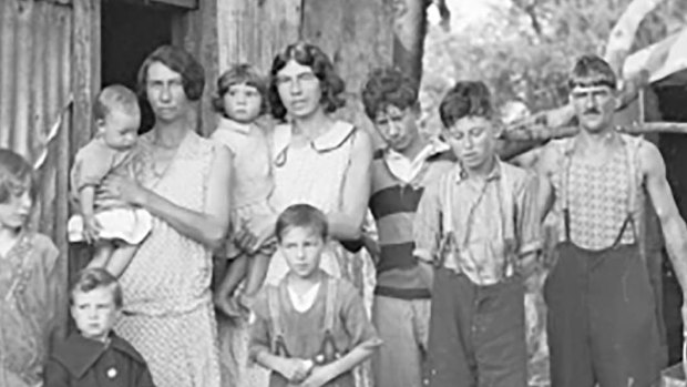 A family standing outside a tin shack called Wiloma in NSW during the Great Depression in 1932.