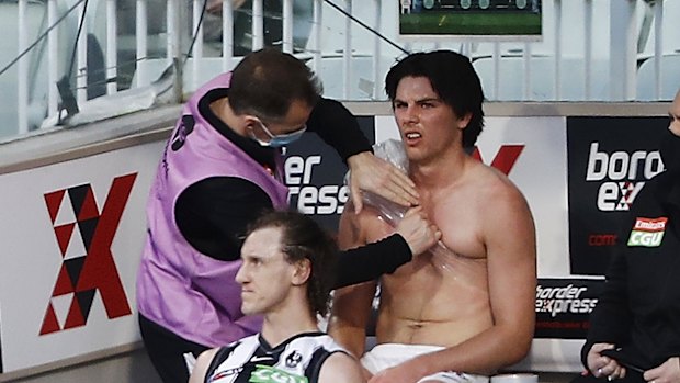 Oliver Henry of the Magpies is seen on the bench with a shoulder injury.