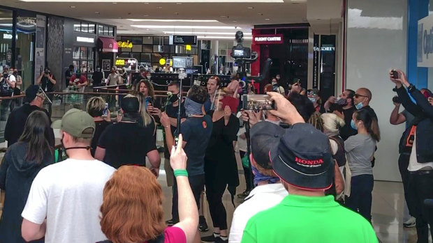 Several dozen anti-lockdown protesters sing John Farnham's 'You're The Voice' as part of their protest at Chadstone shopping centre.