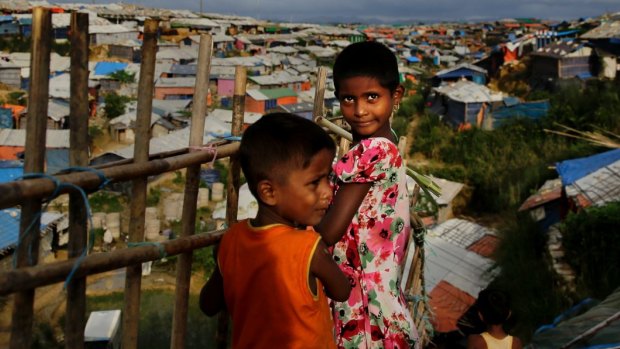 Rohingya children overlook an expanse of makeshift bamboo and tarp shelters at Kutupalong refugee camp.