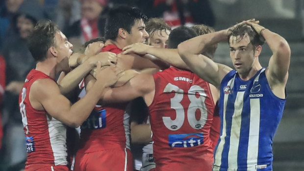 Upset: The Swans celebrate their unexpected victory over North Melbourne.