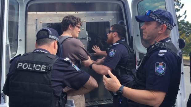 The man is led into a police van after police asked him to move on repeatedly before pulling him away from the protest.