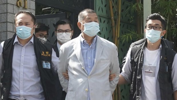 Hong Kong media tycoon Jimmy Lai, center, was perp-walked following his arrest on Monday.