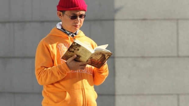Xiao Jianhua, a Chinese-born Canadian billionaire, reads a book outside the International Finance Center in Hong Kong.