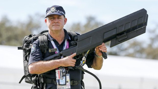 Queensland Police senior sergeant John Hildebrand carrying DroneShield's drone gun, which was used at the Commonwealth Games.