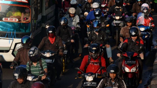 Cars, buses and motorcycles sit in congested traffic in the business district in Jakarta.