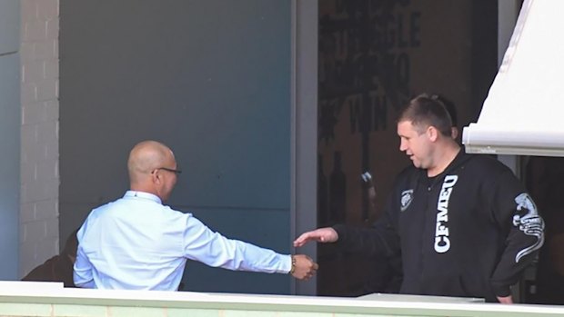Former CFMEU NSW assistant secretary Michael Greenfield (right) and secretary Darren Greenfield (left, obscured) at union headquarters with an employer they received $5000 bribes from.