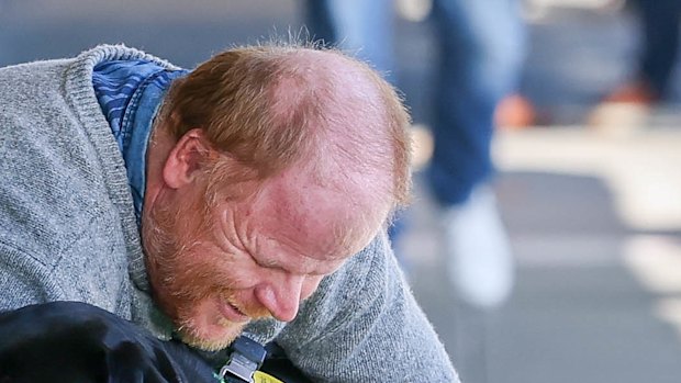 Phillip Chalker hugs his current assistance dog Donna during an outing to a shopping strip in Traralgon.