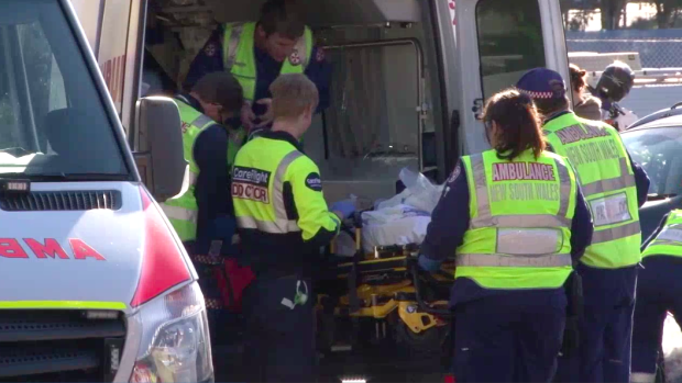 The boy is loaded into an ambulance to be taken to hospital.