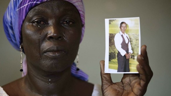 Martha Mark, the mother of kidnapped school girl Monica Mark, cries as she shows her photo in May 2014.