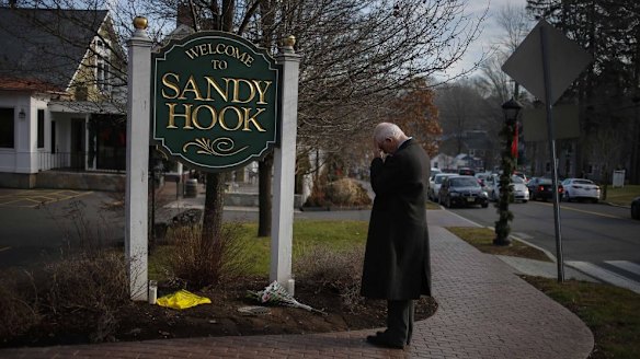 A man pauses to mourn at the entrance to the town of Sandy Hook on December 15, 2012, in the aftermath of the tragedy.