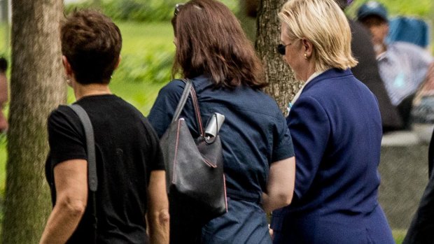 Hillary Clinton (right) is seen leaving the 9/11 ceremony early.