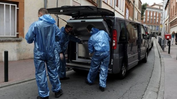 A forensics team loads the remains of a woman onto a vehicle after her dismembered body was found in a plastic storage trunk in a building in Toulouse on August 5, 2015.