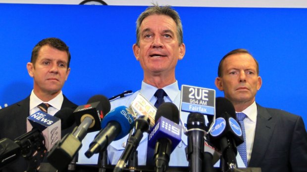 NSW Police Commissioner Andrew Scipione (centre), flanked by NSW Premier Mike Baird and Prime Minister Tony Abbott, has been criticised for failing to resolve the scandal. 