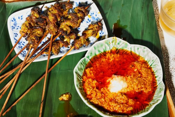 Satay sauce served alongside pork satay skewers.