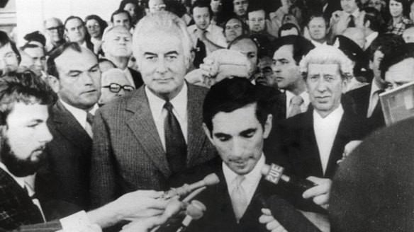 Gough Whitlam stands behind David Smith, the secretary to the Governor-General, as he reads the proclamation dissolving parliament following the dismissal of the Whitlam government.