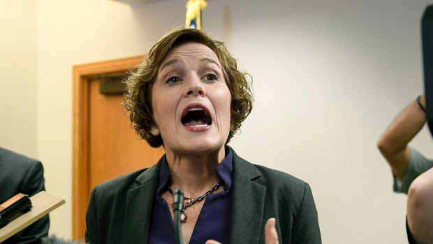 Minneapolis Mayor Betsy Hodges tries to talk to the media as she is shouted at by protesters demanding her resignation on Friday.