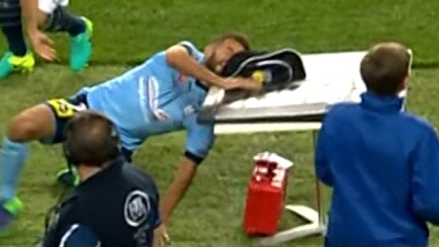 Lucky escape: Sydney FC player Michael Zullo crashes into the sideline table.