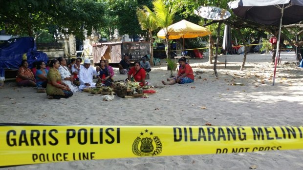 Family of the slain police officer hold a Ngulapin cleansing ceremony on Kuta beach.