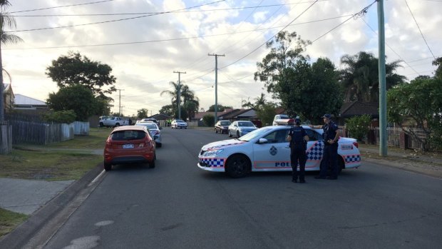 Police have blocked off Barossa Street, Kingston, as they negotiate with an armed man holding a small child hostage.