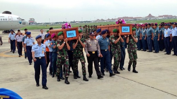 The first two bodies recovered from the AirAsia crash arrive at a military airport in Surabaya. 