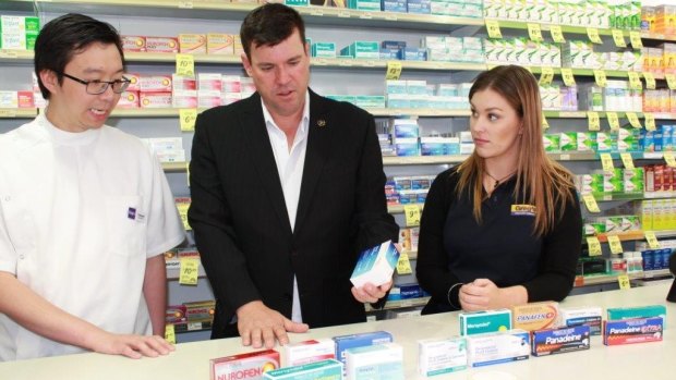 Liberal MP Phil Edman, centre, and staff at the Rockingham pharmacy where a man was arrested.