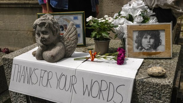 A placard, flowers and pictures are displayed on the tomb of rock singer Jim Morrison at the Pere-Lachaise cemetery in Paris.