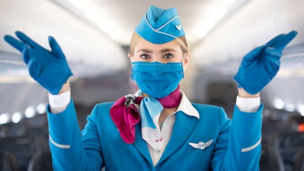 A Eurowings flight attendant wears a mouth and nose protector and gloves.