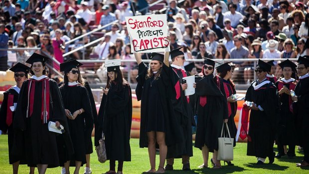 Graduating student, Andrea Lorei, who helped organise campus demonstrations following the Brock Turner case, holds a sign in protest before the 125th Stanford University commencement ceremony in June. 