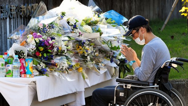 A man prays at a makeshift altar in front of the Tsukui Yamayuri En care centre for the disabled in Sagamihara, Japan. 