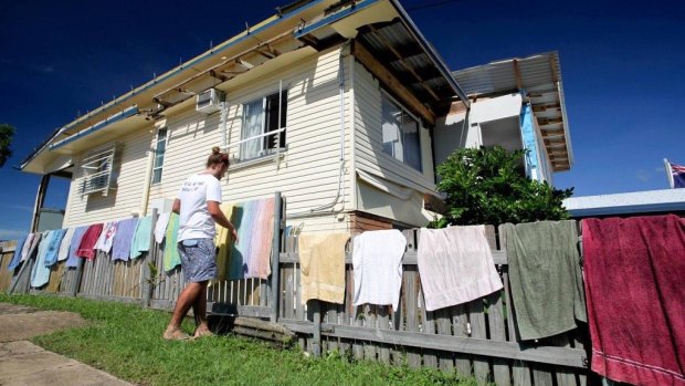 Lucas Patchett of charity laundry service Orange Sky hangs out some washing in front of a Yeppoon home damaged by Cyclone Marcia.