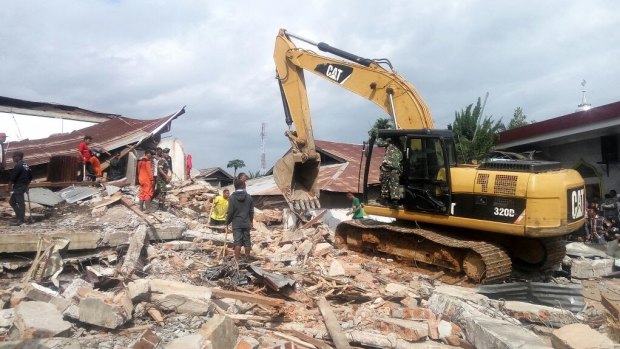 Heavy equipment cleans up a petrol station coffee shop where 10 people were thought to be trapped.