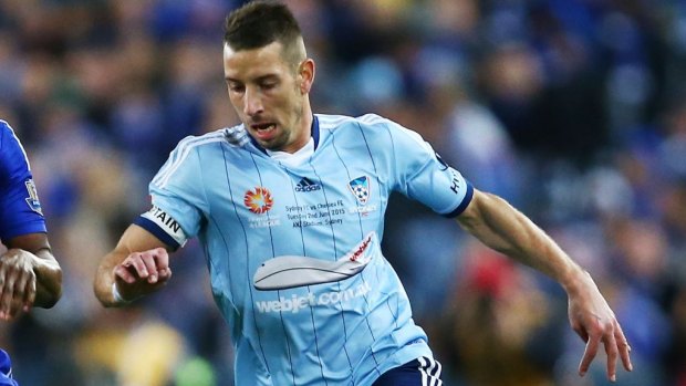 Nikola Petkovic of Sydney FC (right) and John Obi Mikel of Chelsea compete for the ball and run past a paper plane thrown on to the pitch by a fan.