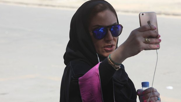 Saudi activist Ghada Ghazzawi tapes a selfie video marking a historical day for Saudi women as she arrives to vote for the municipal elections on December 12, 2015 in Jeddah, Saudi Arabia.
