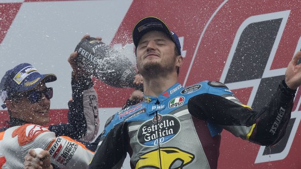 Shock victory: Jack Miller is sprayed with champagne by Marc Marquez after winning his maiden MotoGP race.