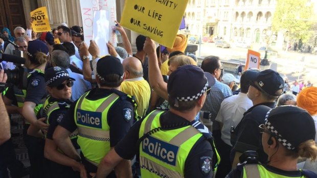 Police linked arms on the steps of Parliament to keep the taxi protesters at bay. 