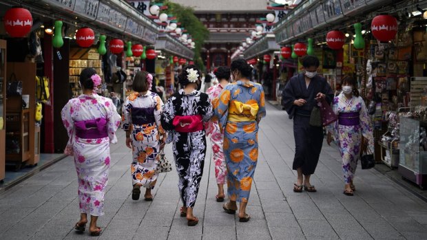Tourists in traditional Japanese kimonos walk in Asakusa district in Tokyo.