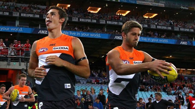 Tough start: Phil Davis and Callan Ward run out onto the field during the round one match between the  Giants and the Swans in 2012.